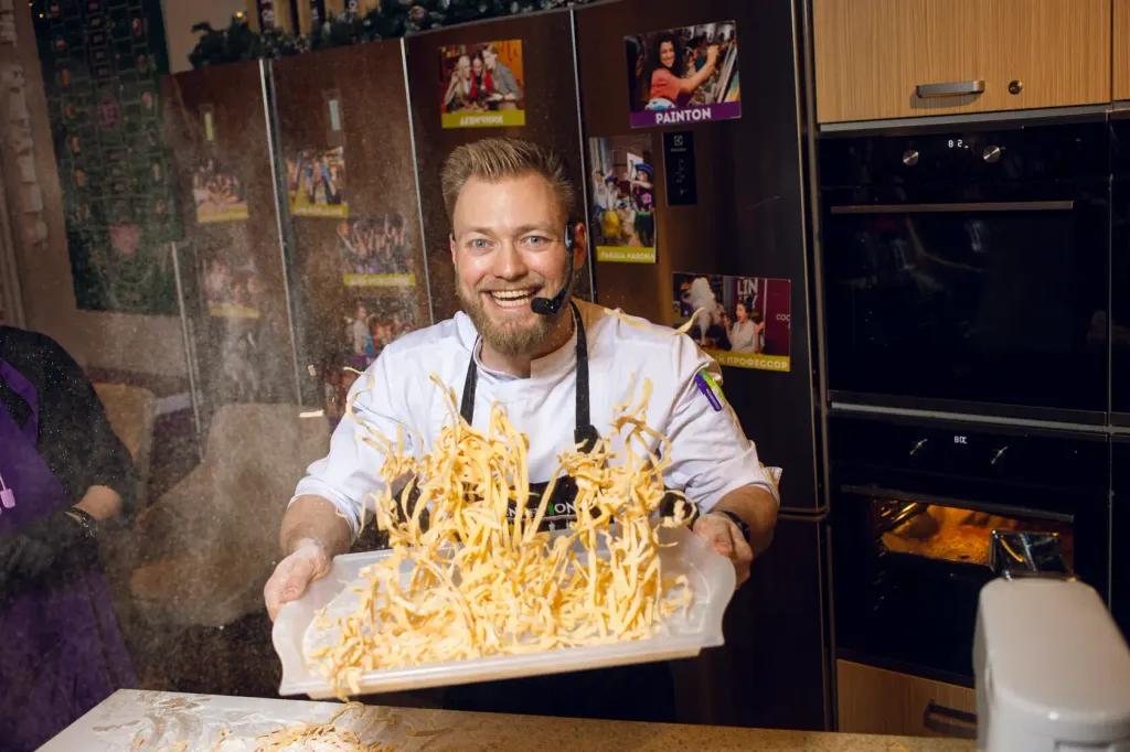 Мастер-класс для мужчин в CulinaryOn — шеф-повар с улыбкой держит свежую домашнюю пасту